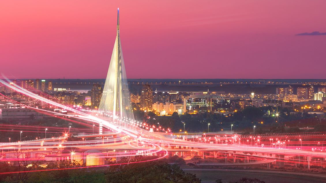 Most na Adi i panorama Beograda u sumrak sa svetlosnim tragovima optičke FiberPro internet mreže.