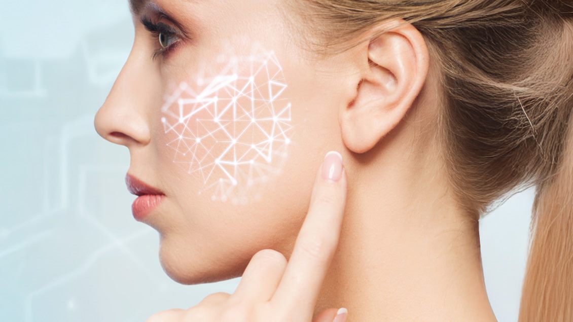 Profil žene koja dotiče svoje uvo, na čijem se obrazu nalazi digitalni mrežni šablon.