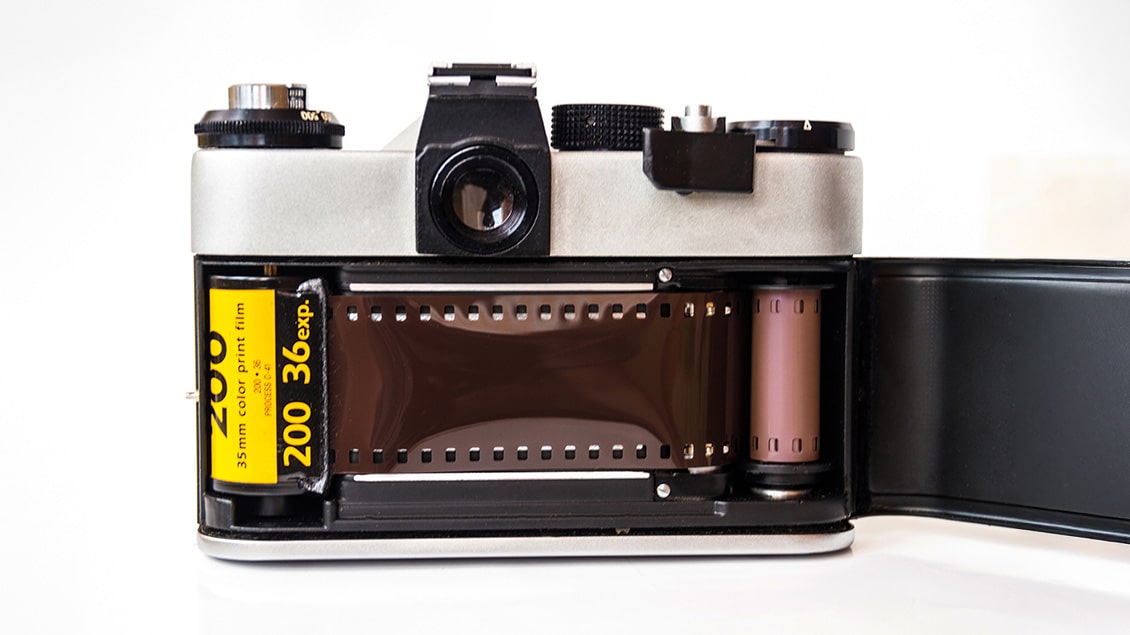 Otvoreni analogni fotoaparat sa umetnutim Kodak 35mm filmom, simbol prelaza iz analogne u digitalnu fotografiju.