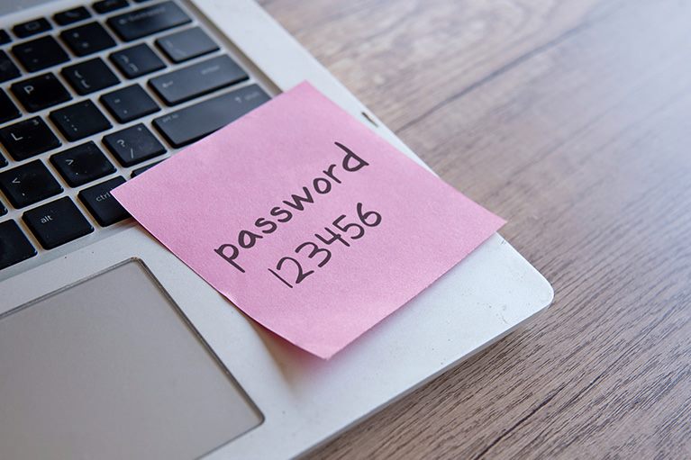 Papirić sa lozinkom 123456 zalepljen na laptop – primer nesigurne lozinke