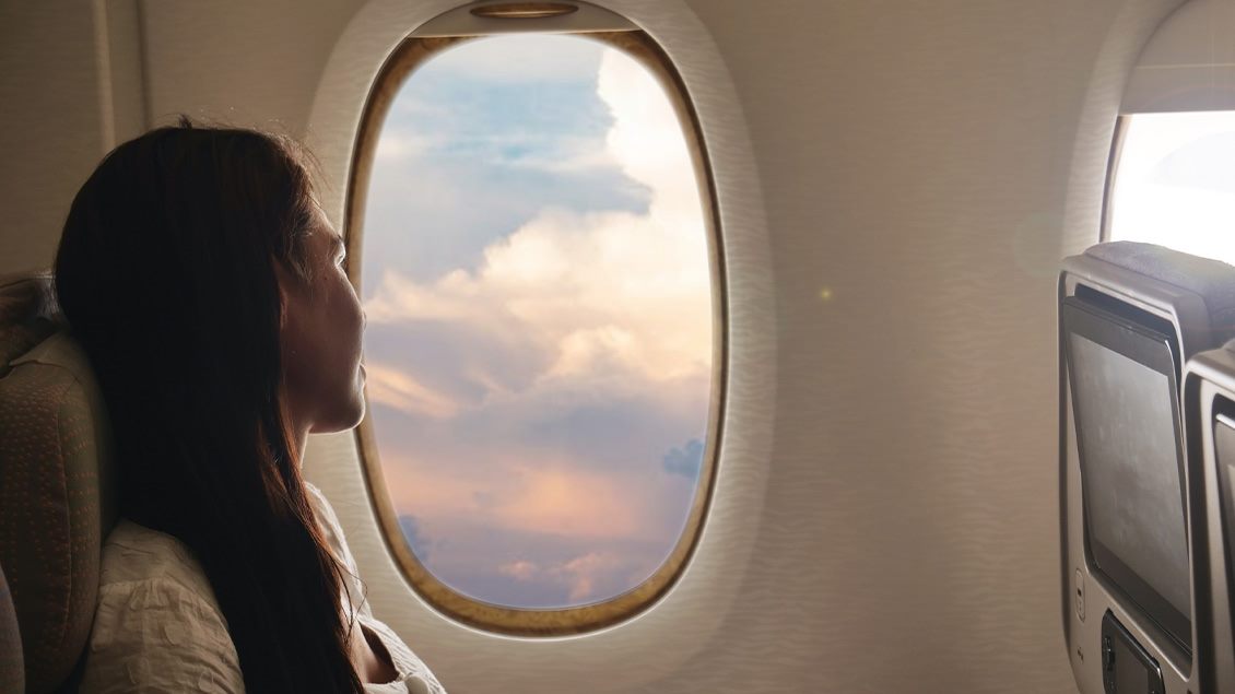 devojka gleda kroz avionsko okno.