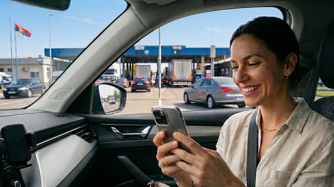 Žena u automobilu dobija SMS potvrdu o aktivaciji putnog osiguranja pri prelasku granice