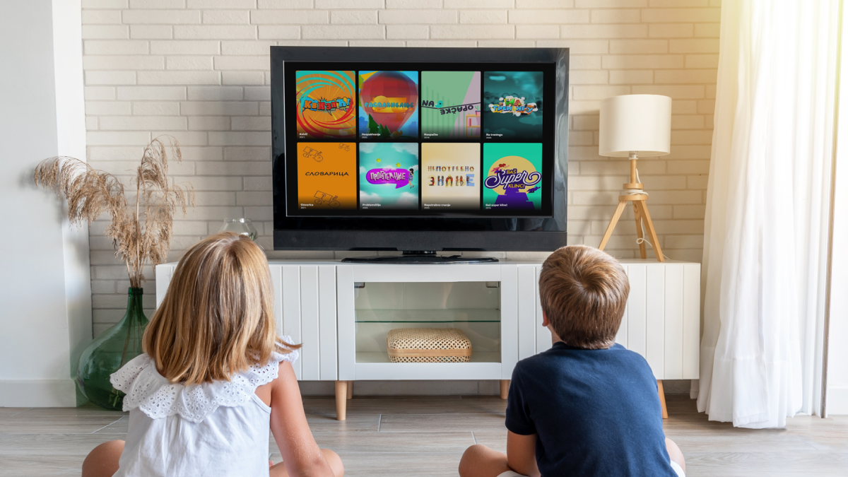 Deca gledaju edukativne i zabavne sadržaje za najmlađe na televizoru u dnevnoj sobi.